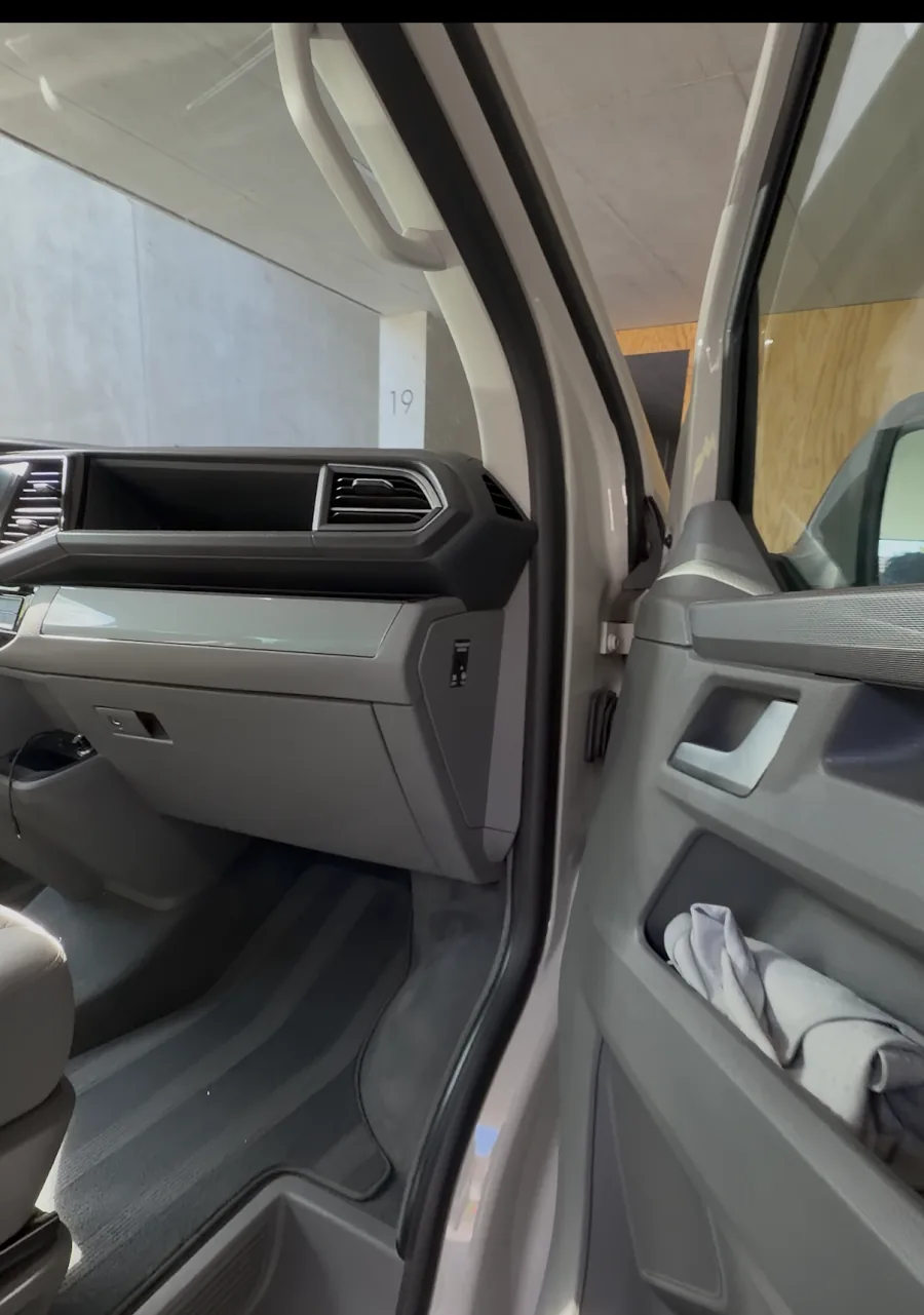 Gereinigtes Armaturenbrett und Türverkleidung eines VW Bus mit sauberen Fussmatten